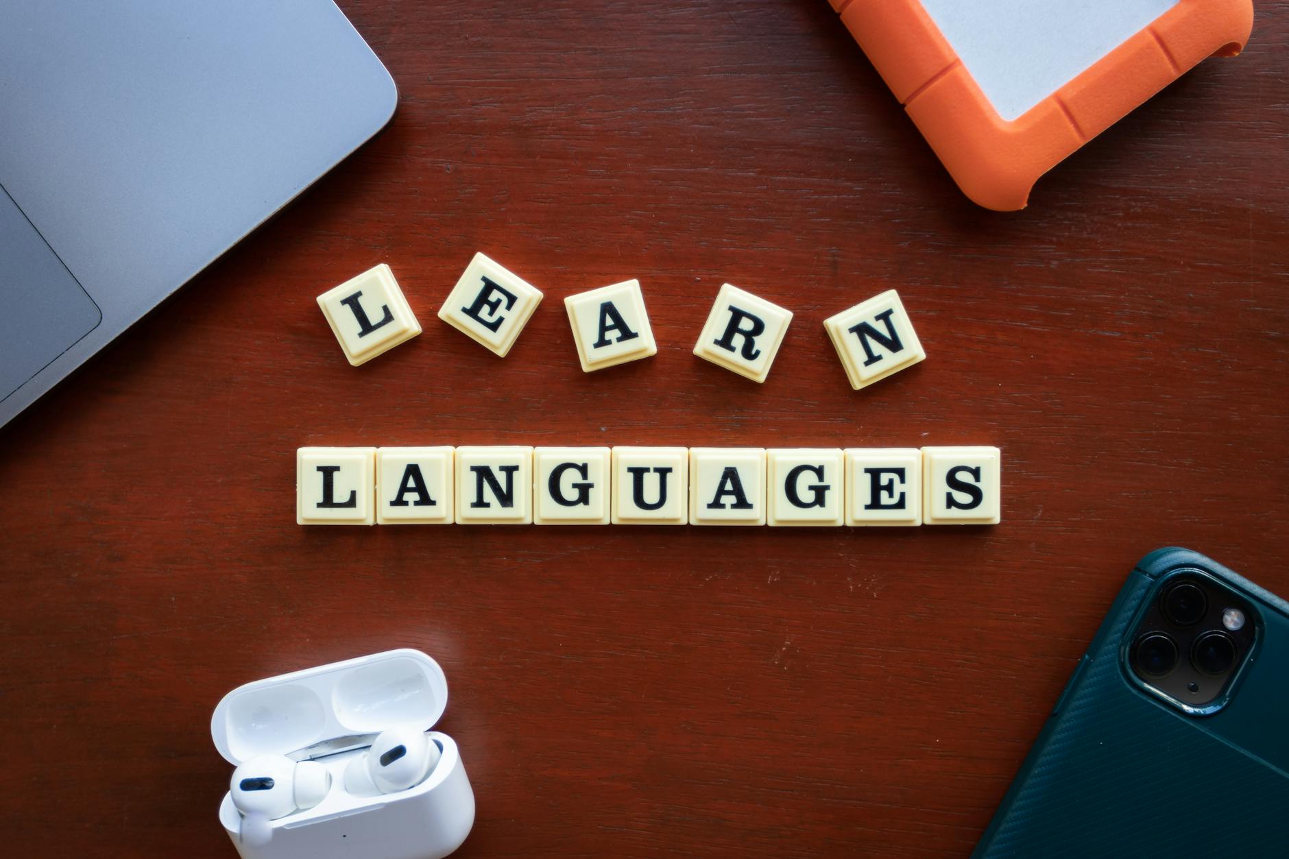 Materiały do nauki języków i gadżety edukacyjne ułożone na biurku